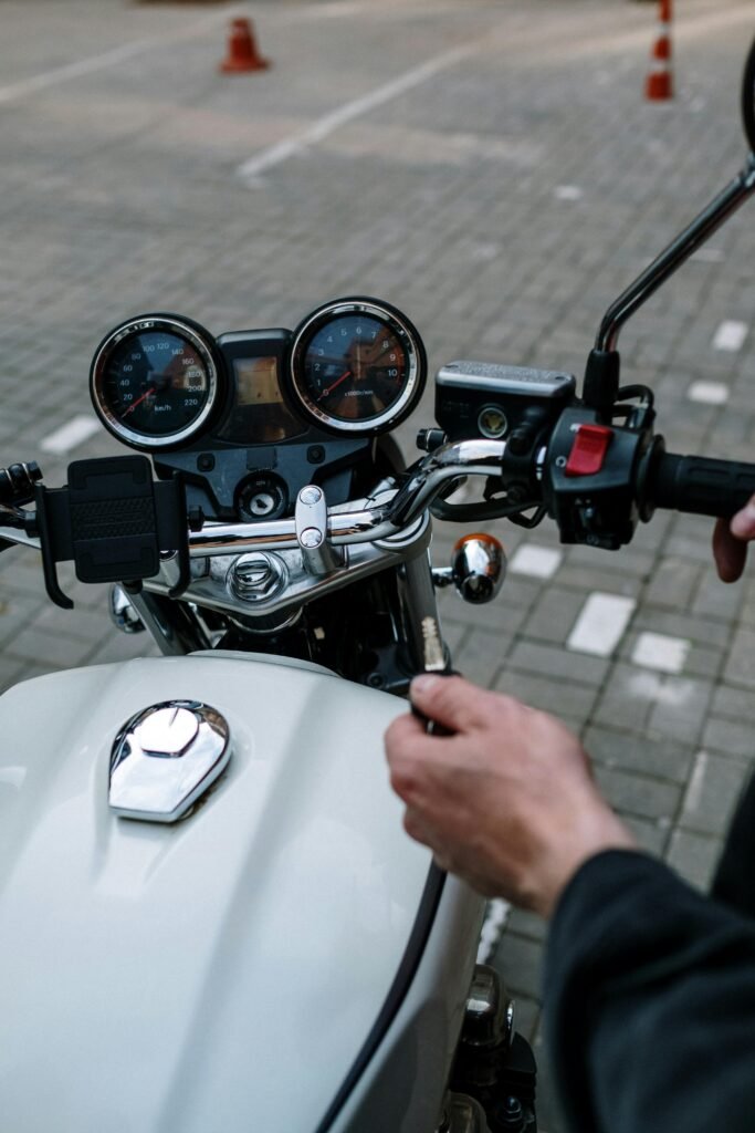 Motorcyclist holding handlebar focusing on speedometer and controls.